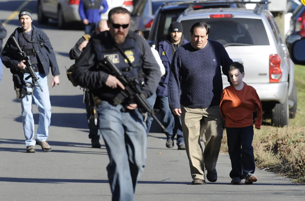 Parents leave a staging area after being reunited with their children following a shooting at the Sandy Hook Elementary School in Newtown, Conn., on Dec. 14, 2012. (Jessica Hill/AP Photo)