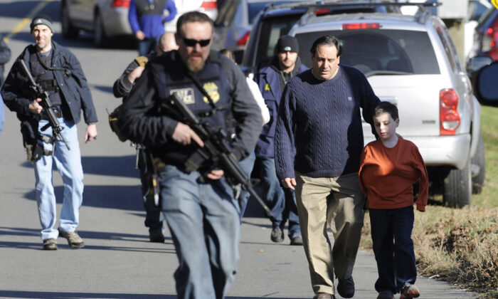 Parents leave a staging area after being reunited with their children following a shooting at the Sandy Hook Elementary School in Newtown, Conn., on Dec. 14, 2012. (Jessica Hill/AP Photo)