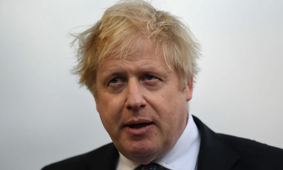 UK Prime Minister Boris Johnson speaks with members of the media during a visit to Warszawska Brygada Pancerna military base in Warsaw, Poland, on Feb. 10, 2022.  (Daniel Leal/Pool/Getty Images)