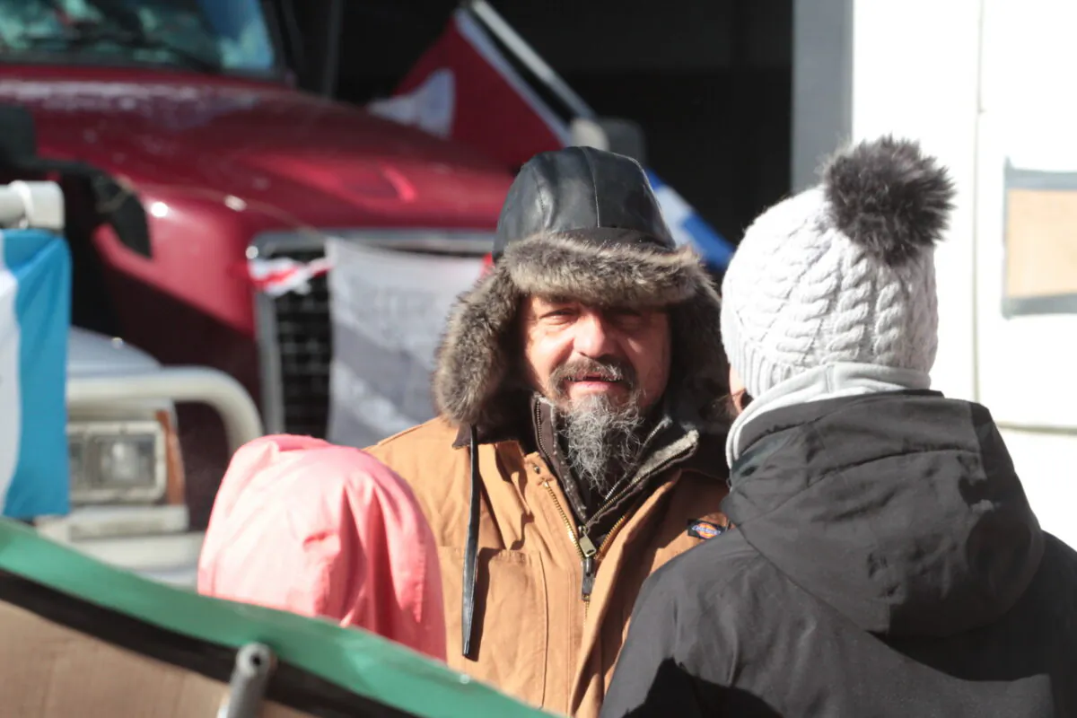 A trucker talks with a supporter in Ottawa, Canada on Feb.14, 2022. (Richard Moore/The Epoch Times)