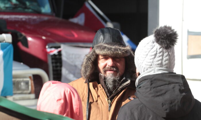 A trucker talks with a supporter in Ottawa, Canada on Feb.14, 2022. (Richard Moore/The Epoch Times)