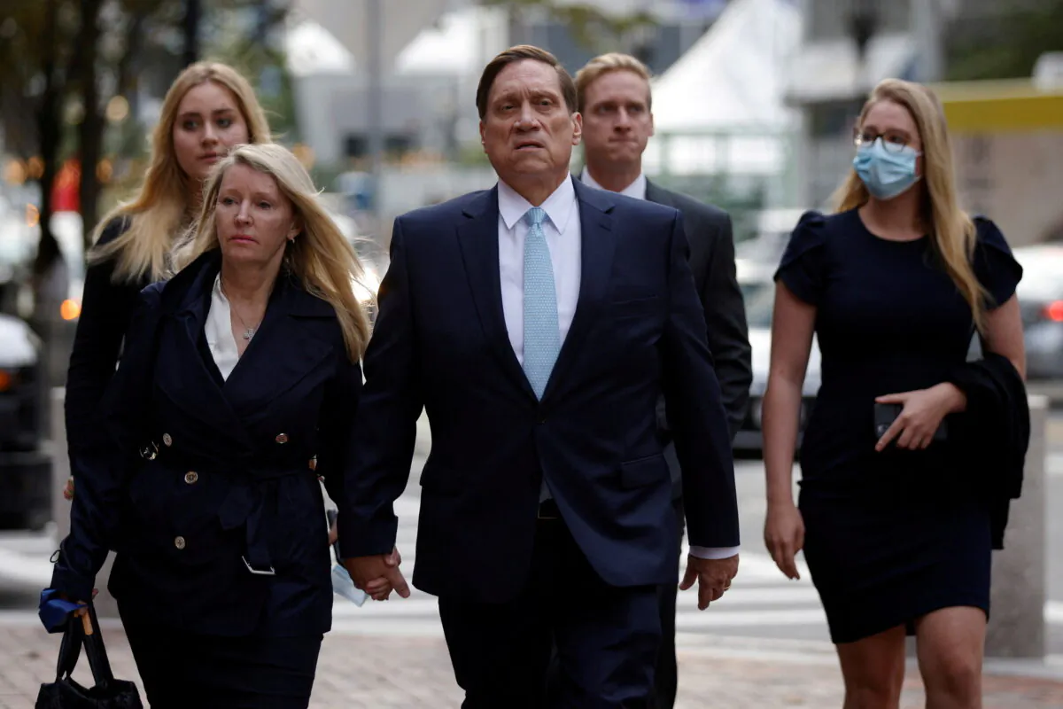 Private equity firm founder John Wilson (C) arrives at federal court in Boston, on Oct. 6, 2021. (Brian Snyder/Reuters)