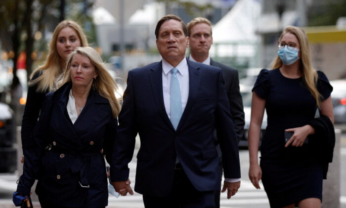 Private equity firm founder John Wilson (C) arrives at federal court in Boston, on Oct. 6, 2021. (Brian Snyder/Reuters)