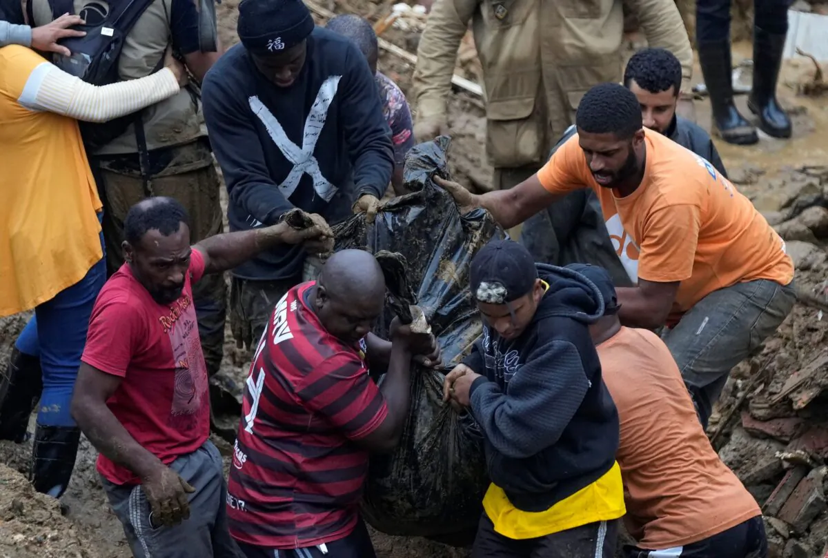 Residents and volunteers remove the body of a mudslide victim in Petropolis, Brazil, on Feb. 16, 2022. (Silvia Izquierdo/AP Photo)
