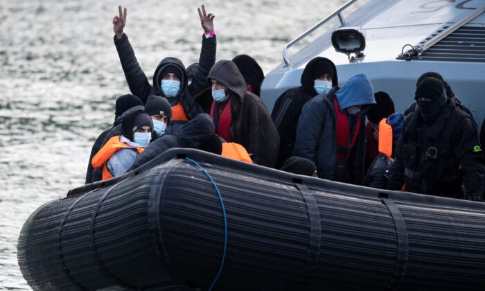 Illegal immigrants react onboard UK Border Force vessel HMC Speedwell after being picked up at sea, as they are brought into the Marina in Dover, southeast England, on Dec. 21, 2021. (Ben Stansall/AFP via Getty Images)