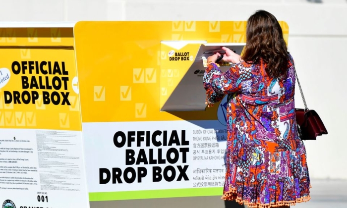 A woman casts her ballot for thr 2020 US Elections at an officla Orange County ballot drop-box at the Orange County Registrar's Office in Santa Ana, California on October 13, 2020. (FREDERIC J. BROWN/AFP via Getty Images)