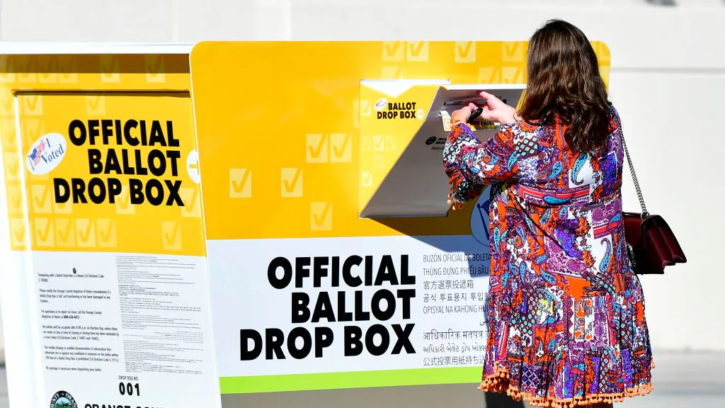 A woman casts her ballot for the 2020 US Elections at an official Orange County ballot drop-box at the Orange County Registrar's Office in Santa Ana, Calif., on Oct. 13, 2020. (Frederic J. Brown/AFP via Getty Images)