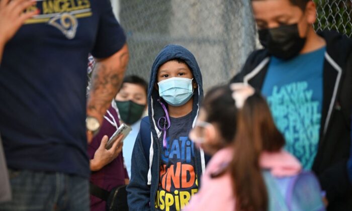 Students and parents wearing face coverings wait in line for the first day of the school year at Grant Elementary School in Los Angeles, Calif., on Aug. 16, 2021. (Robyn Beck/AFP via Getty Images)