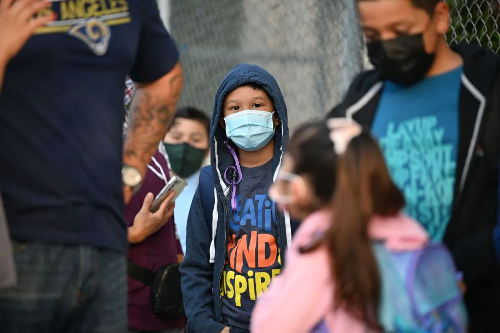 Students and parents wearing face coverings wait in line for the first day of the school year at Grant Elementary School in Los Angeles, Calif., on Aug. 16, 2021. (Robyn Beck/AFP via Getty Images)