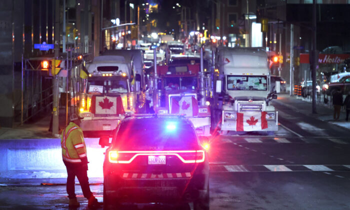 A police vehicle blocks a downtown street to prevent trucks from joining a blockade of truckers protesting vaccine mandates near the Parliament Buildings on February 15, 2022 in Ottawa, Ontario, Canada (Photo by Scott Olson/Getty Images)