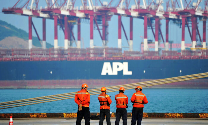 Workers stand near a container ship at the port in Qingdao, a city in eastern China's Shandong Province, on June 8, 2017. (STR/AFP via Getty Images)