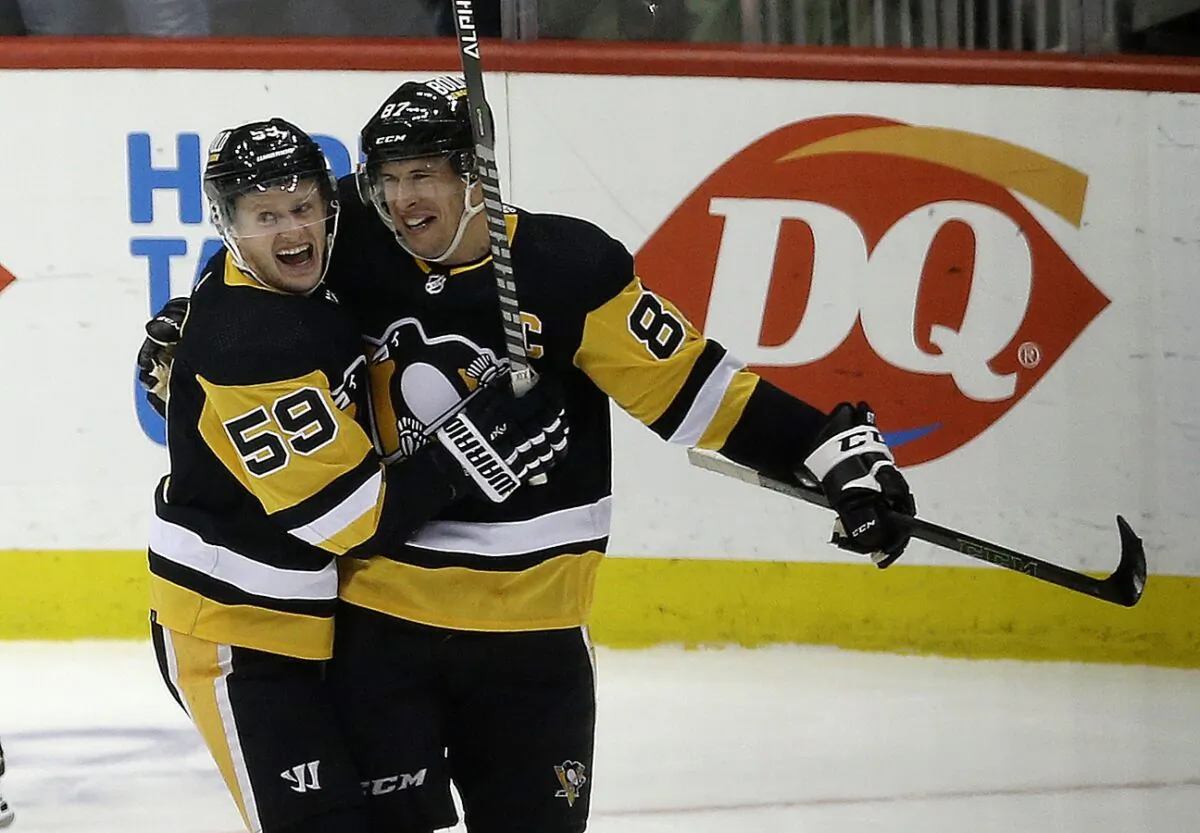 Pittsburgh Penguins left wing Jake Guentzel (59) congratulates center Sidney Crosby (87) after Crosby scored his 500th career NHL goal against the Philadelphia Flyers during the first period at PPG Paints Arena in Pittsburgh, on Feb. 15, 2022. (Charles LeClaire/USA TODAY Sports via Field Level Media)