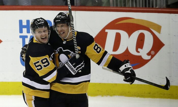 Pittsburgh Penguins left wing Jake Guentzel (59) congratulates center Sidney Crosby (87) after Crosby scored his 500th career NHL goal against the Philadelphia Flyers during the first period at PPG Paints Arena in Pittsburgh, on Feb. 15, 2022. (Charles LeClaire/USA TODAY Sports via Field Level Media)