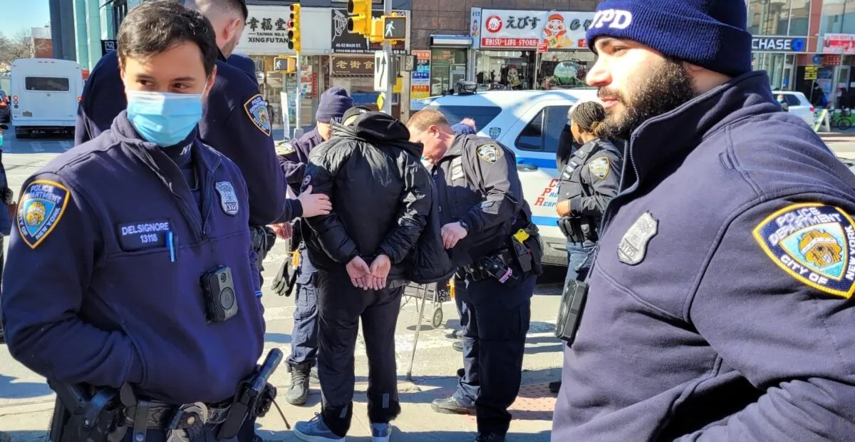 Police arrest Zheng Buqiu for attacking information booths held by Falun Gong practitioners, in Flushing, New York, on Feb. 15, 2022. (Provided to The Epoch Times)

