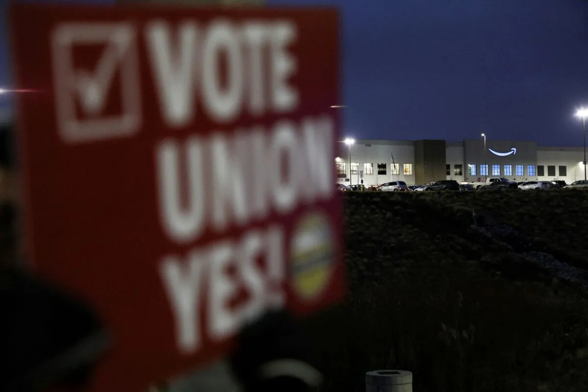 A person affiliated with RWDSU (Retail, Wholesale and Department Store Union) holds a sign supporting unionization in front of an Amazon facility on the first day of the unionization vote in Bessemer, Ala., on Feb. 4, 2022. (Dustin Chambers/Reuters)