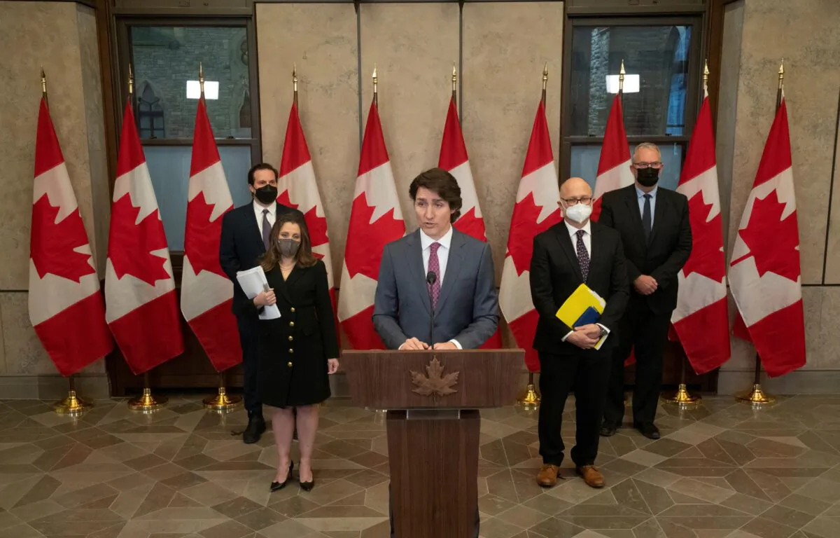 Prime Minister Justin Trudeau, flanked by cabinet ministers including Deputy Prime Minister Chrystia Freeland, announces that the Emergencies Act will be invoked to deal with protests, in Ottawa on Feb. 14, 2022. (The Canadian Press/Adrian Wyld)