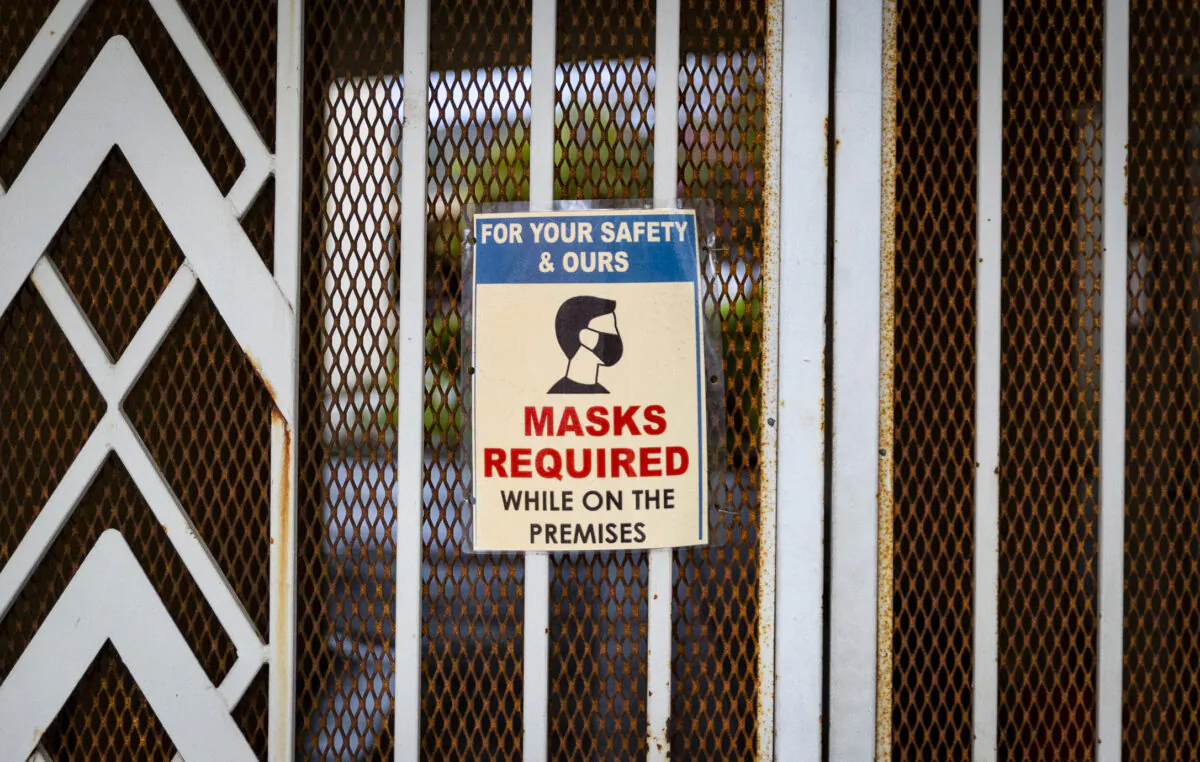 A sign requesting masks hangs on a doorway in Tustin, Calif., on March 10, 2021. (John Fredricks/The Epoch Times)