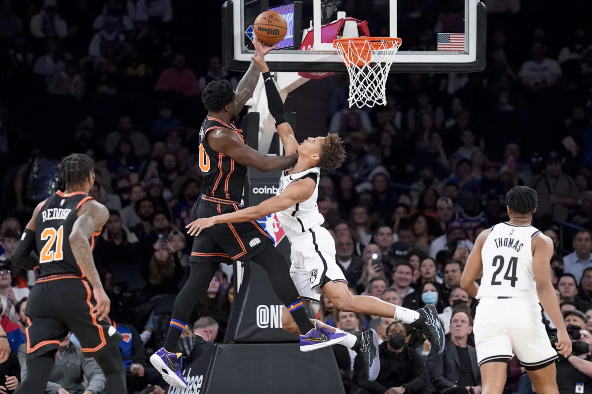 New York Knicks forward Julius Randle, center left, scores against Brooklyn Nets forward Kessler Edwards, center right, during the first half of an NBA basketball game, in New York City,  on Feb. 16, 2022. (John Minchillo/AP Photo)