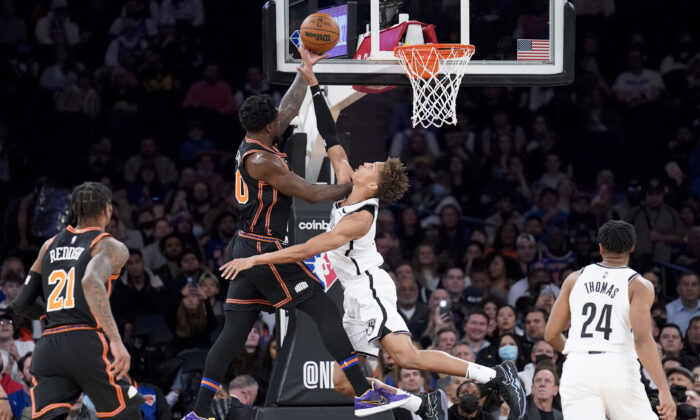 New York Knicks forward Julius Randle, center left, scores against Brooklyn Nets forward Kessler Edwards, center right, during the first half of an NBA basketball game, in New York City,  on Feb. 16, 2022. (John Minchillo/AP Photo)