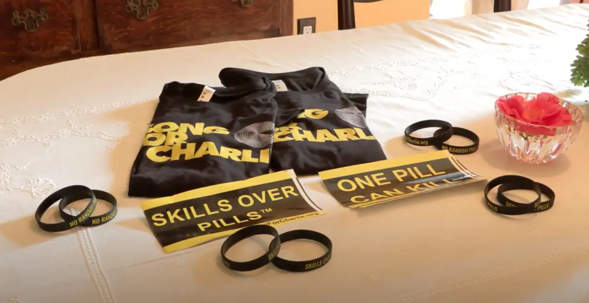 Shirts and wristbands for the organization “Song for Charlie” displayed on a table on Feb. 1, 2022. (Annie Wang/NTD Television)