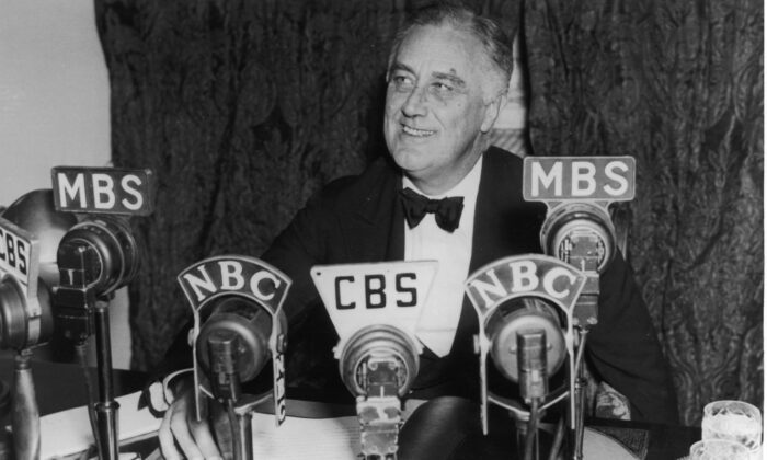 President Franklin D. Roosevelt seated in front of a number of television and radio station microphones in Washington asking communities to continue relief work, Oct. 14, 1938. (Fotosearch/Getty Images).

