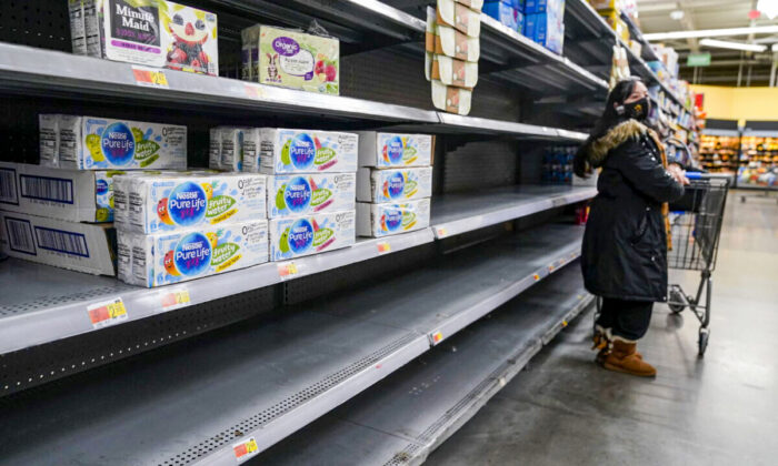 A woman looks over shelves, some of which are empty, at a Walmart store in Teterboro, N.J., on Jan. 12, 2022. The Justice Department is launching a new initiative aimed at identifying companies that exploit supply chain disruptions in the U.S. to make increased profits in violation of federal antitrust laws. (AP Photo/Seth Wenig, File)