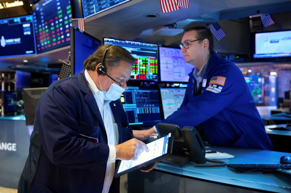 Trader John Santiago (L) and specialist Patrick King work on the trading floor at the New York Stock Exchange on Feb. 18, 2022. (Allie Joseph/New York Stock Exchange via AP)