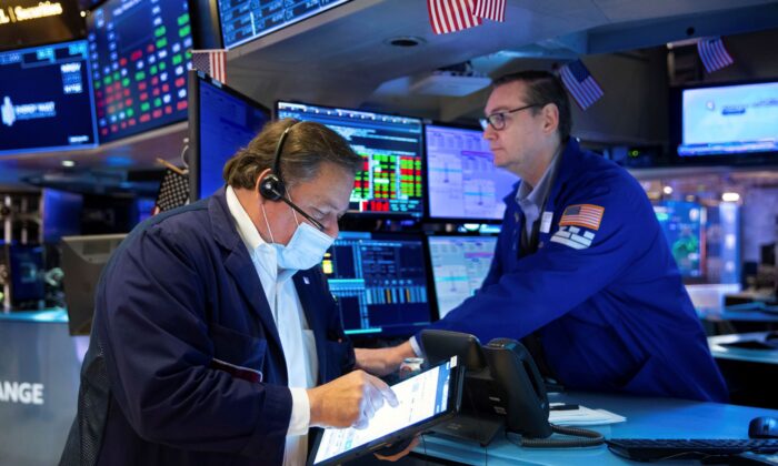 Trader John Santiago (L) and specialist Patrick King work on the trading floor at the New York Stock Exchange on Feb. 18, 2022. (Allie Joseph/New York Stock Exchange via AP)