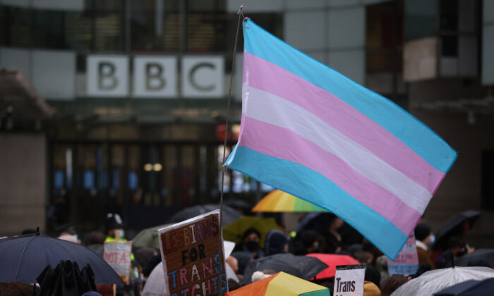 Demonstrators hold placards and wave a transgender pride flag during the Trans Activism UK "British Bigotry Corporation: Platforming Hate Is Not Impartial" protest at BBC Broadcasting House in London on Jan. 8, 2022. (Hollie Adams/Getty Images)