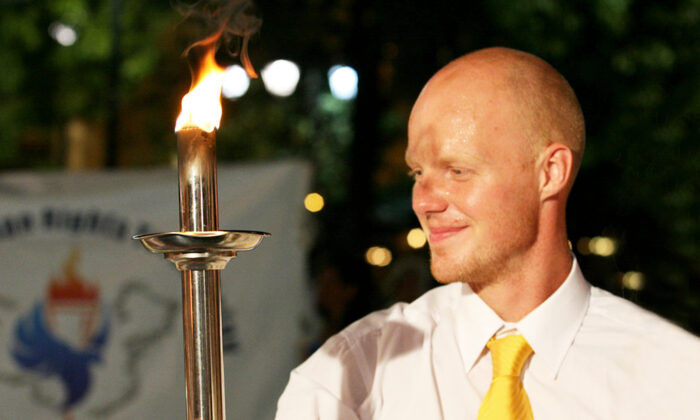 Olympic medalist Martins Rubenis holds up the Human Rights Torch at the official opening of the Global Human Rights Torch Relay in Athens, Greece, on the evening of Aug. 9, 2007. (longtrekhome/Flickr)