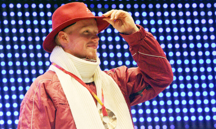 Bronze medalist Latvia’s Martins Rubenis celebrates during a 2006 Winter Olympics medal ceremony in Turin, Italy, on Feb. 13, 2006, a day after the singles luge final. (Thomas Coex/AFP via Getty Images)