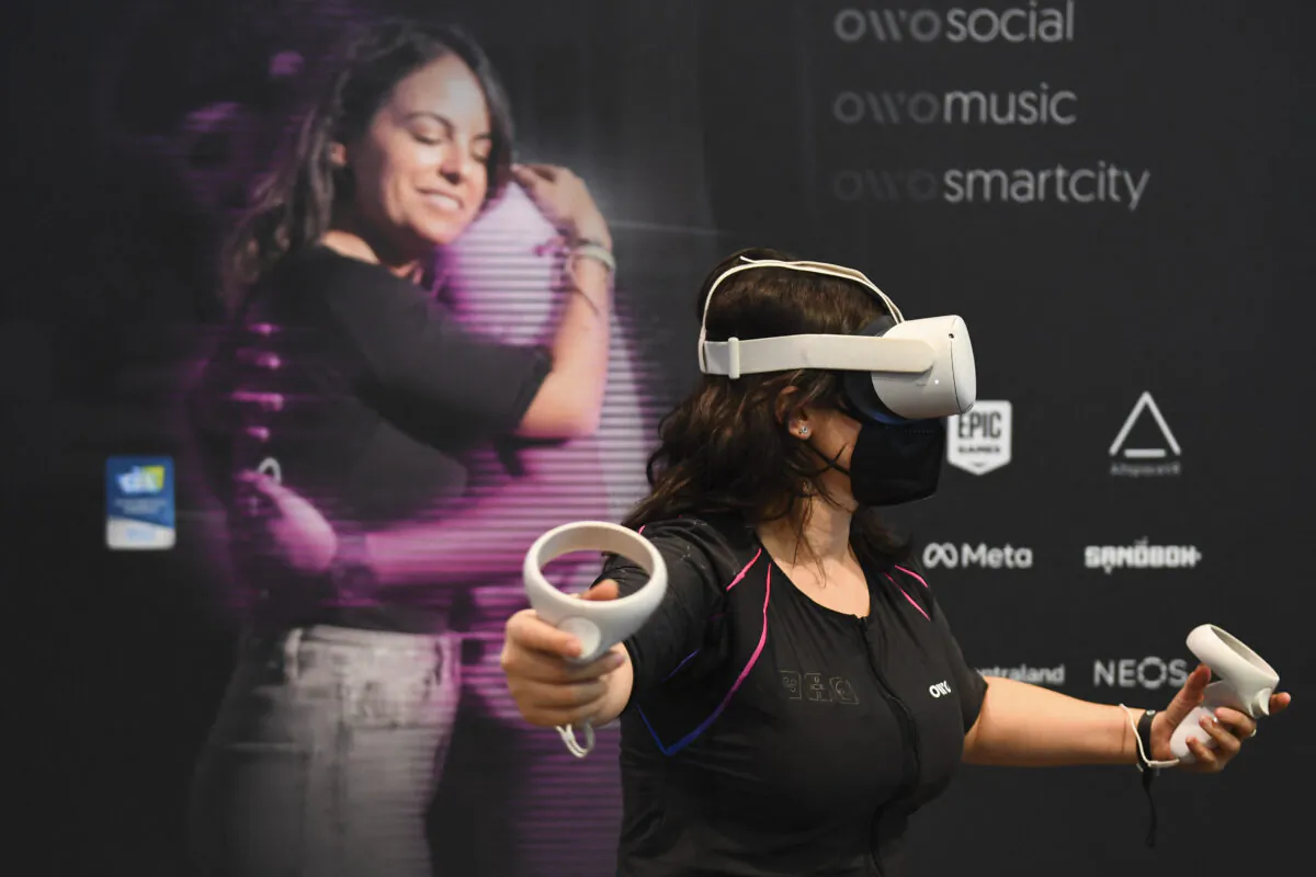 An attendee demonstrates the Owo vest, which allows users to feel physical sensations during metaverse experiences such as virtual reality games, including wind, gunfire, or punching, at the Consumer Electronics Show (CES) in Las Vegas, Nev., on Jan. 5, 2022. (Patrick T. Fallon/AFP via Getty Images)