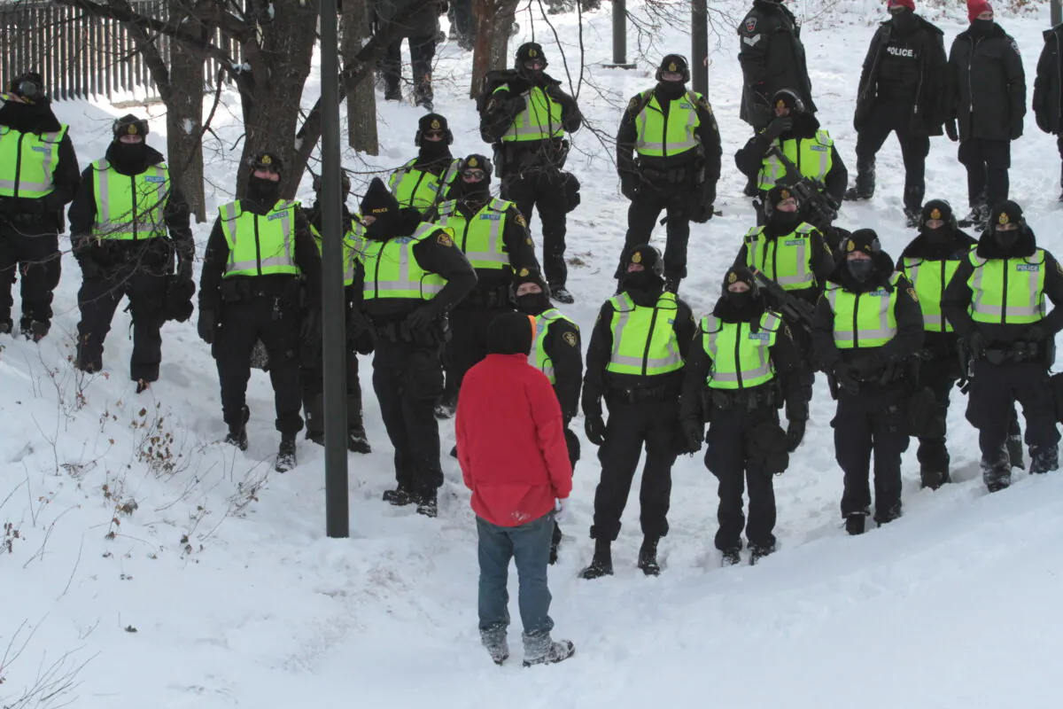 A lone protester confronts police in Ottawa on Feb. 18, 2022. (Richard Moore/The Epoch Times)