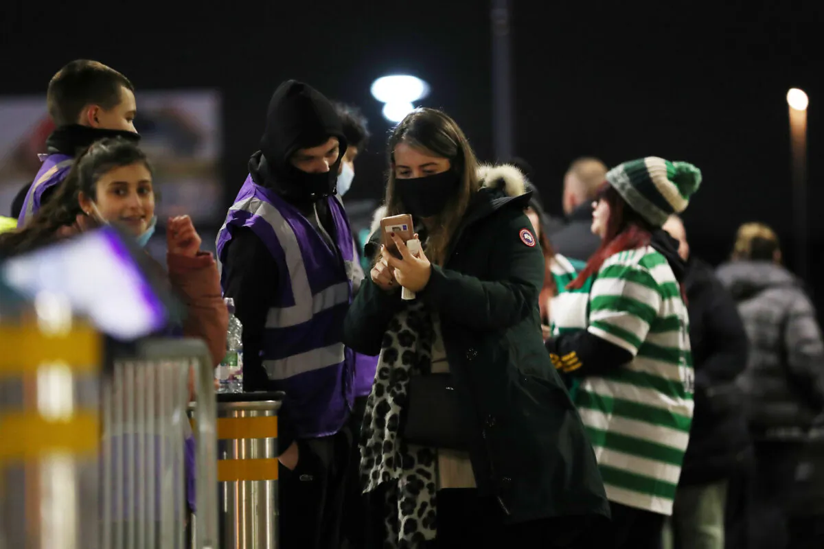 Fans show proof of their COVID-19 status before entering a stadium in Glasgow, Scotland, in a file image. (Ian MacNicol/Getty Images)