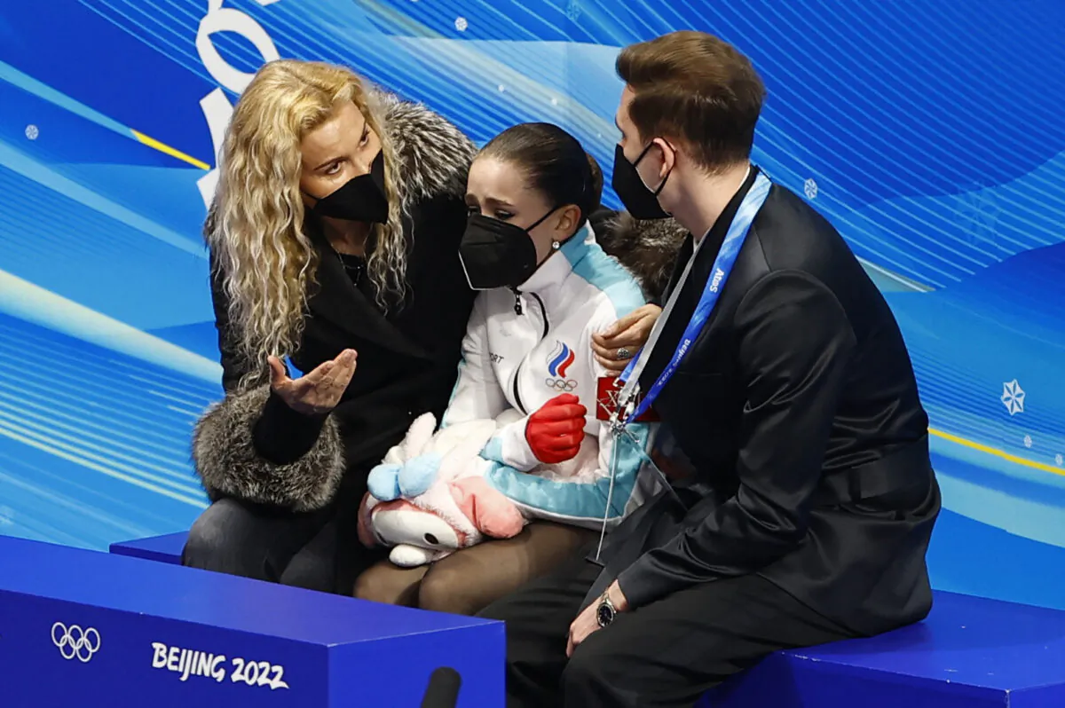 Kamila Valieva (C) of the Russian Olympic Committee reacts with coaches Daniil Gleikhengauz (R) and Eteri Tutberidze (L) after her performance in the women's free skating program during the figure skating competition at the 2022 Winter Olympics in Beijing on Feb. 17, 2022. (Evgenia Novozhenina/Reuters)
