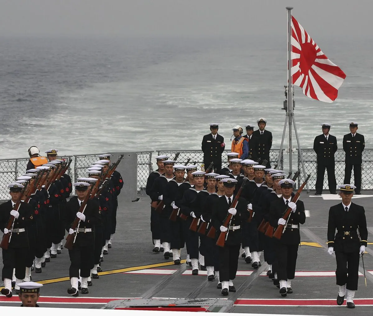 Members of the Japanese Maritime Defence Force march on board a ship during a naval fleet review on October 29, 2006 off Sagami Bay, Japan. (Koichi Kamoshida/Getty Images)