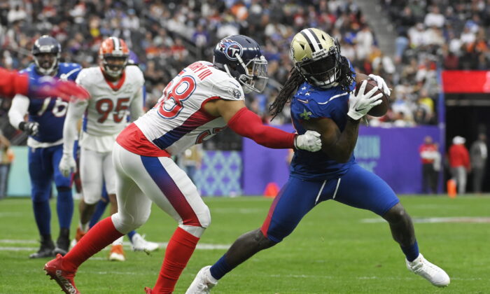 NFC running back Alvin Kamara (41), of the New Orleans Saints, rushes against AFC outside linebacker Harold Landry (58), of the Tennessee Titans, during the first half of the Pro Bowl NFL football game, Sunday, Feb. 6, 2022, in Las Vegas. (AP Photo/David Becker)
