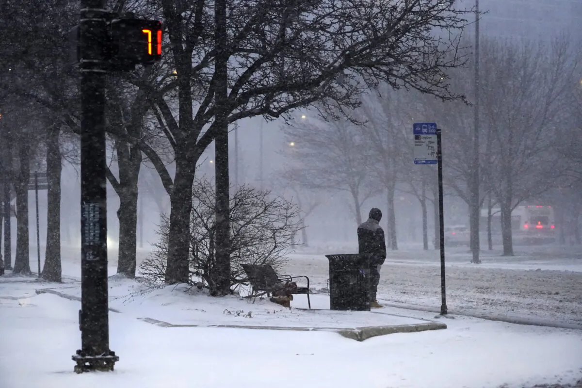 A transit rider waits for a bus as a winter storm descends upon Chicago, on Feb. 17, 2022. (Charles Rex Arbogast/AP Photo)
