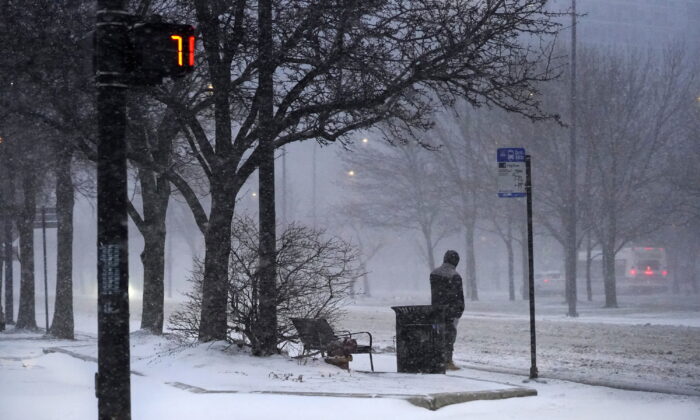 A transit rider waits for a bus as a winter storm descends upon Chicago, on Feb. 17, 2022. (Charles Rex Arbogast/AP Photo)