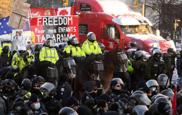 A mounted police unit lines up behind public order units on foot to clear protesters in Ottawa on Feb. 18, 2022. (The Canadian Press/Adrian Wyld)