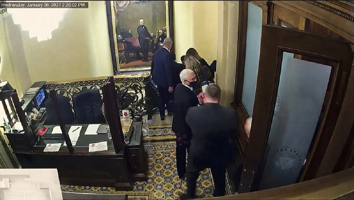 In this image from video shown during former President Donald Trump's second impeachment trial on Feb. 10, 2021, security footage shows then-Vice President Mike Pence being evacuated, as rioters breach the U.S. Capitol in Washington, on Jan. 6, 2021. (Senate Television via AP)