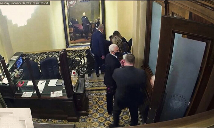 In this image from video shown during former President Donald Trump's second impeachment trial on Feb. 10, 2021, security footage shows then-Vice President Mike Pence being evacuated, as rioters breach the U.S. Capitol in Washington, on Jan. 6, 2021. (Senate Television via AP)