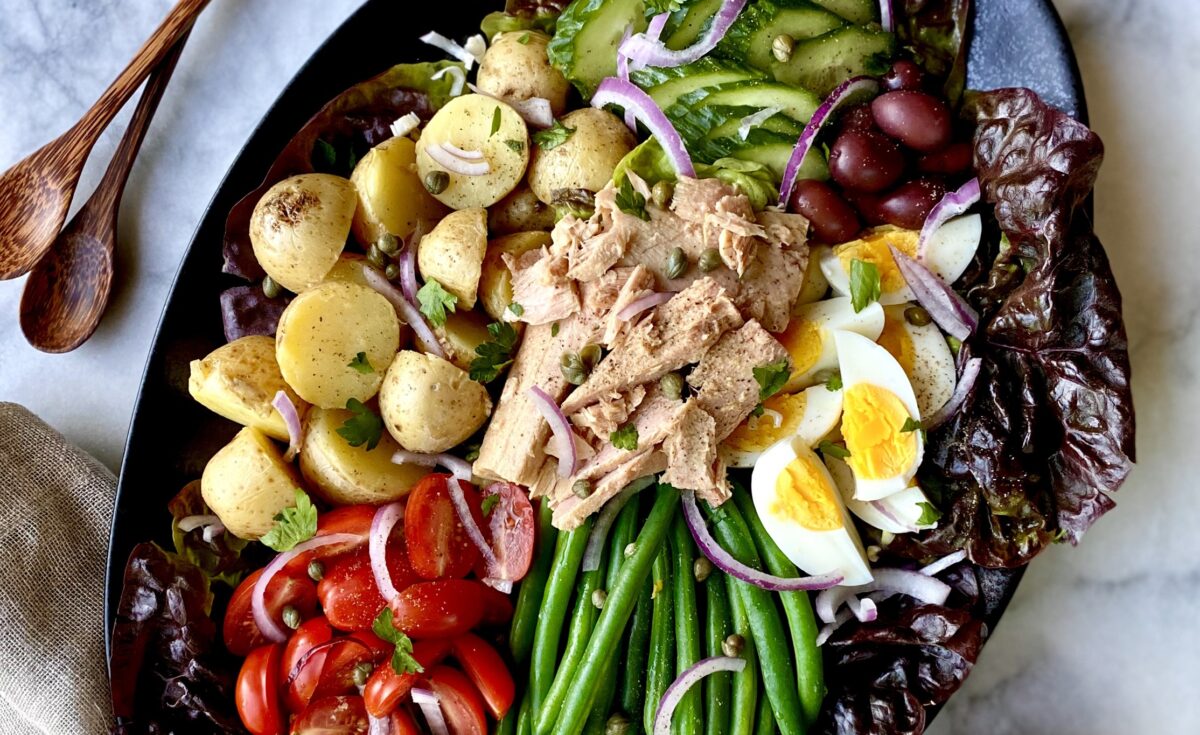 High-quality oil-packed tuna plays co-star to a medley of vegetables, hard-boiled eggs, and a smattering of salty, briny garnishes in this colorful salad. (Lynda Balslev for Tastefood)