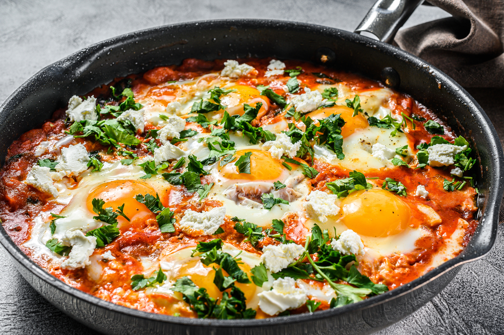 At the heart of shakshouka are eggs poached sunny side up in a pan of simmering tomato sauce, sometimes sweet, sometimes spicy. (Mironov Vladimir/Shutterstock)