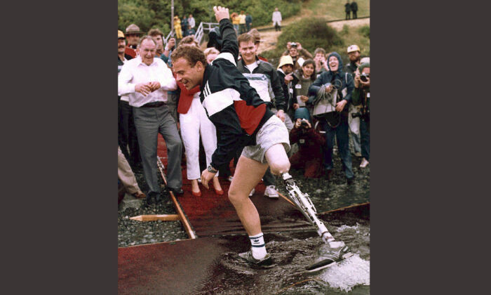 Steve Fonyo dips his artificial limb in the Pacific Ocean in Victoria after completing his cross-country run in this 1985 photo. (The Canadian Press/Chuck Stoody)