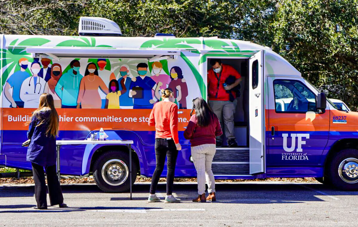William Moody exits a PANDEMIC bus in a YMCA parking lot after receiving his COVID-19 vaccine booster shot on his way to work Feb. 9. (Natasha Holt/The Epoch Times)