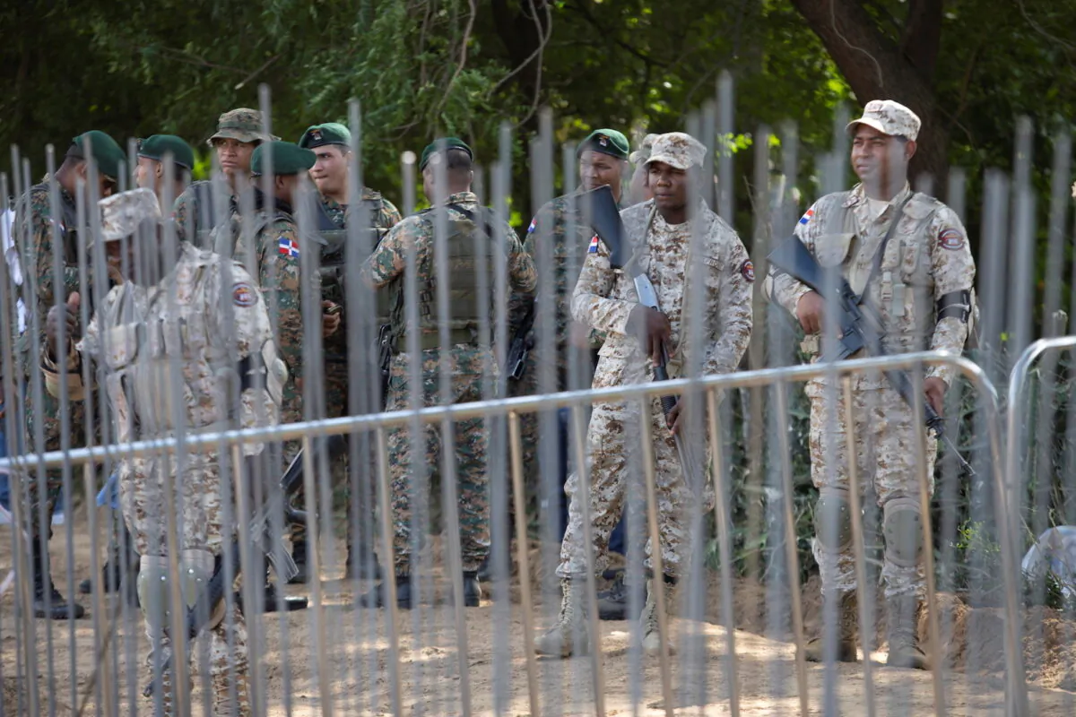 Dominican Republic soldiers keep watch near the construction of a border wall that will cover almost half of the border with Haiti to stop illegal immigration and criminal activities in Abanico, in Dajabon Province, Dominican Republic, on Feb. 20, 2022. (Fran Afonso/Reuters)