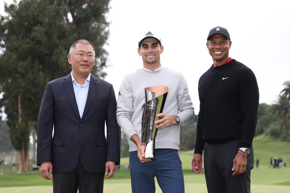 Joaquín Niemann (C) of Chile celebrates with the trophy alongside tournament host Tiger Woods (R) and Jaehoon Chang (L), President & CEO of Hyundai Motor Company, after winning during the final round of The Genesis Invitational at Riviera Country Club, in Pacific Palisades, Calif., February 20, 2022.(Rob Carr/Getty Images)