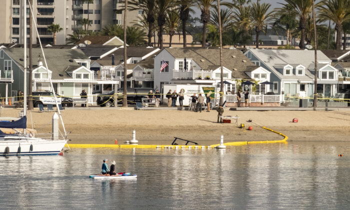 Law enforcement officials investigate the crash site of a Huntington Beach Police Department helicopter that crashed into Newport Harbor on the night of Feb. 19, 2022. Newport Beach, Calif., on Feb. 20, 2022. (John Fredricks/The Epoch Times)