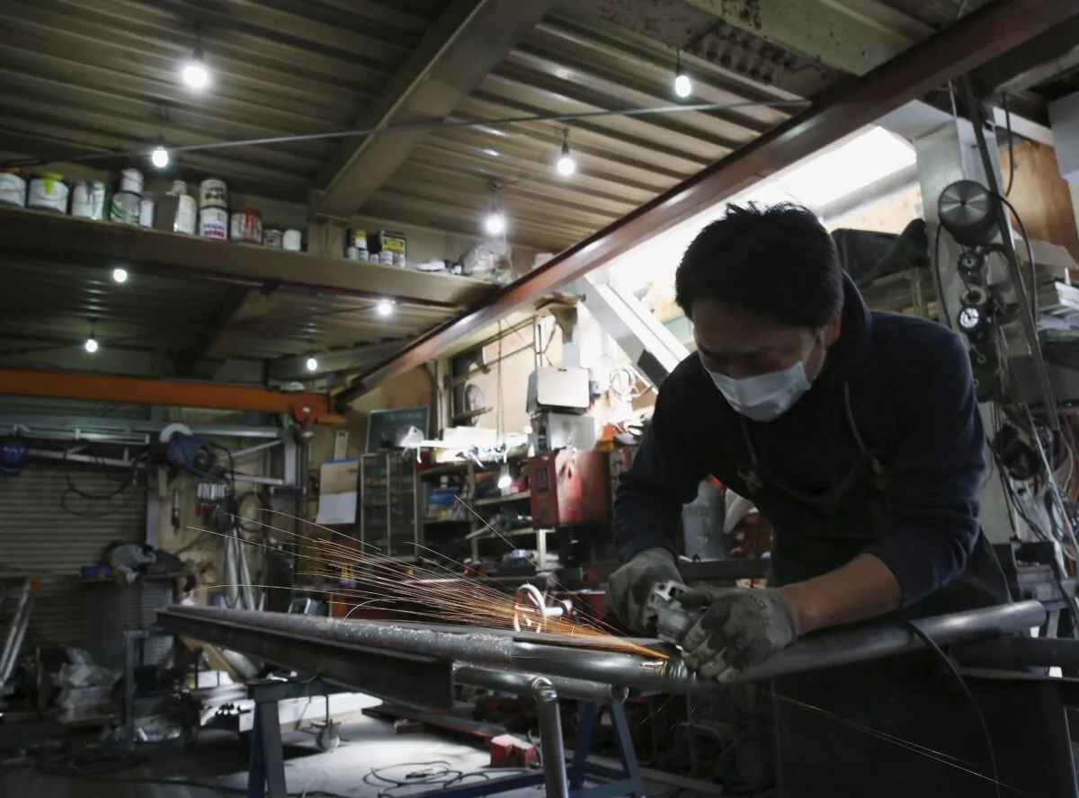 An engineer makes an arm rail for residential buildings inside a metal processing factory at an industrial zone in downtown Tokyo, Japan, on March 22, 2016. (Yuya Shino/Reuters)